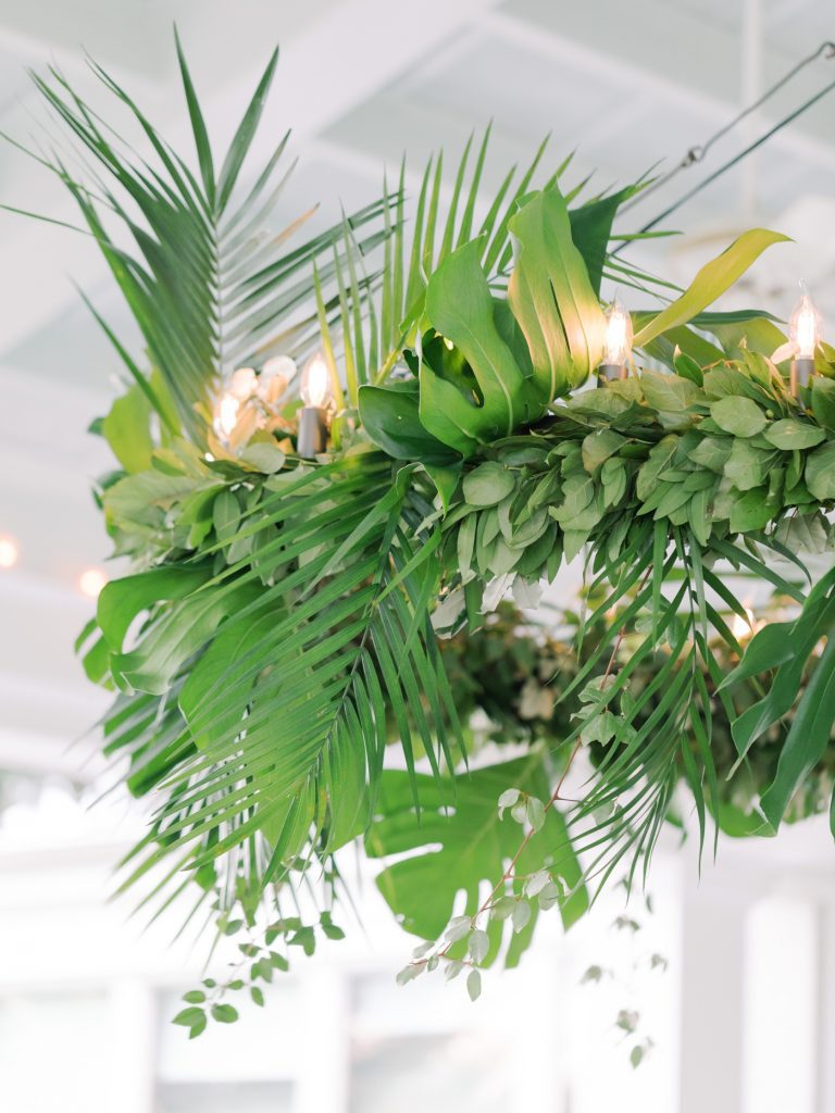 Chandelier covered in palm leaves and ferns for a Savannah wedding