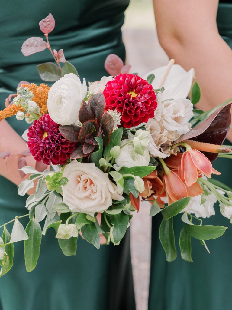 Green satin bridesmaids dresses with tropical bouquets