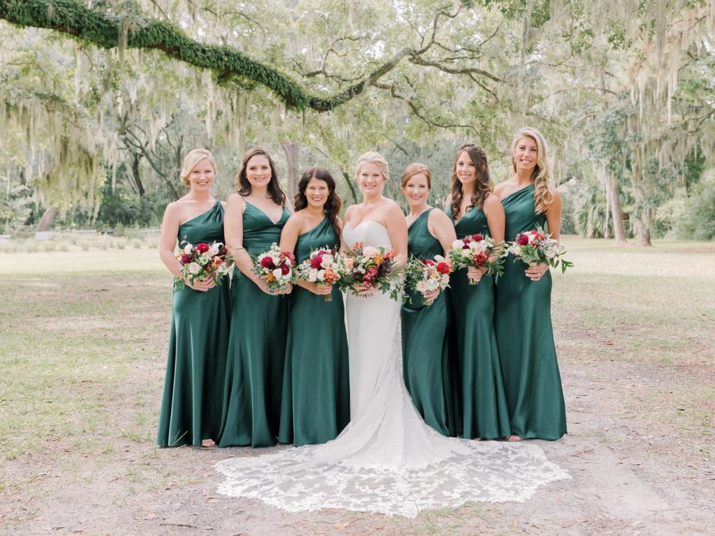 Green satin bridesmaids dresses with tropical bouquets