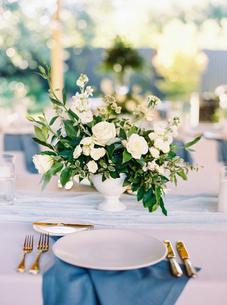 White wedding centrepiece with white and blue table decor
