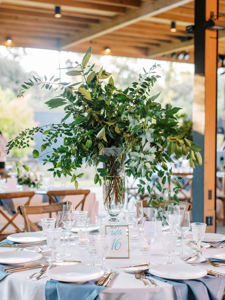 Tall wedding centrepiece with greenery