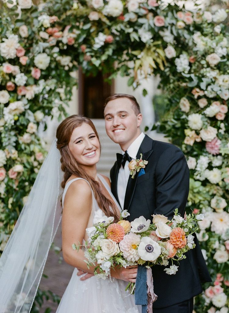 Savannah bride and groom with floral wedding ceremony arch