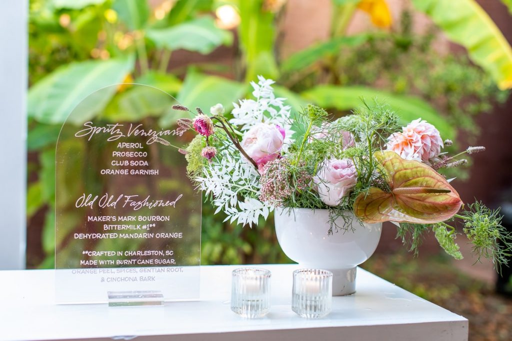 modern acrylic bar signage with modern pink and white floral arrangement