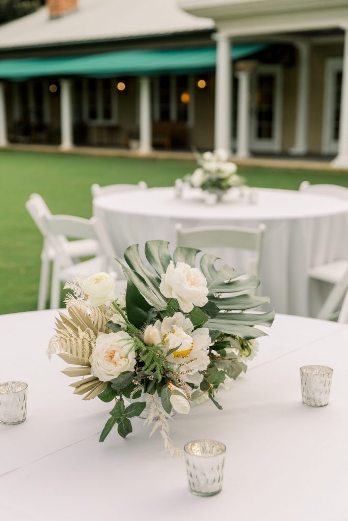 White floral centrepiece with tropical palm leaves