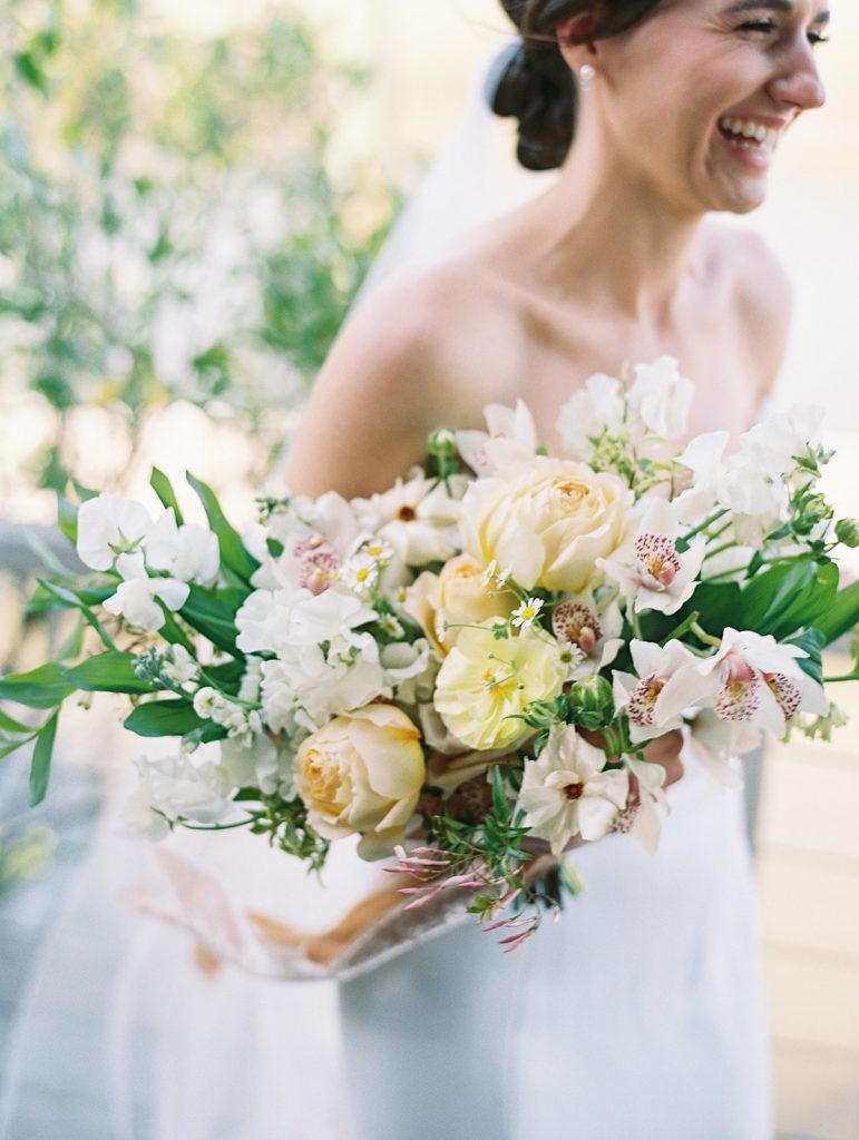 Savannah bride with wedding bouquet made of peach, orange and yellow flowers