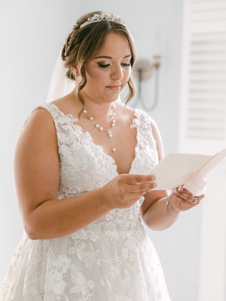 Southern bride in lace wedding dress reading a card