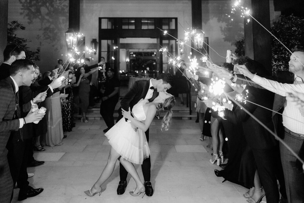 Bride and groom kissing at sparkler exit