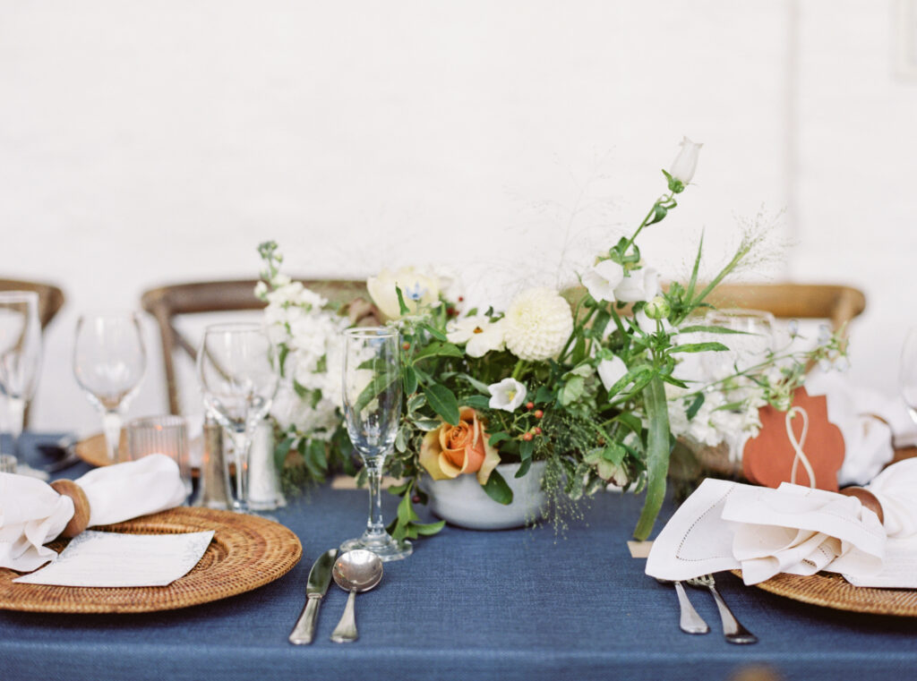 floral centrepiece on blue linen tables