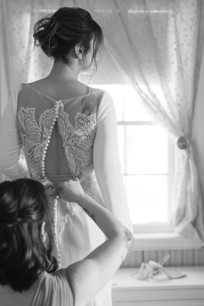 Bride getting dress buttoned up