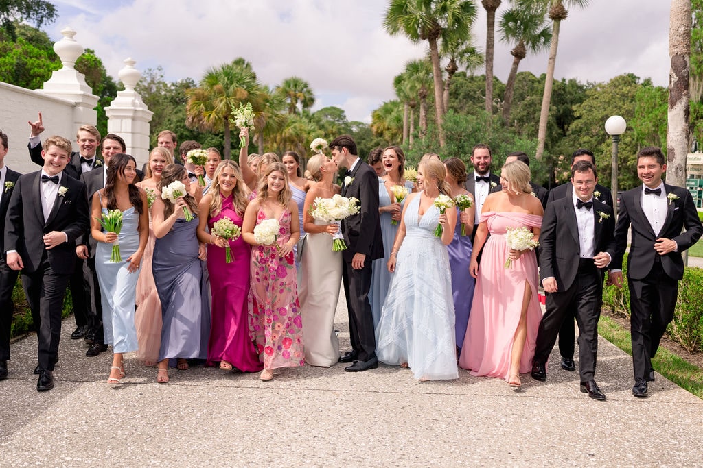 Bride and groom kissing infront of wedding party