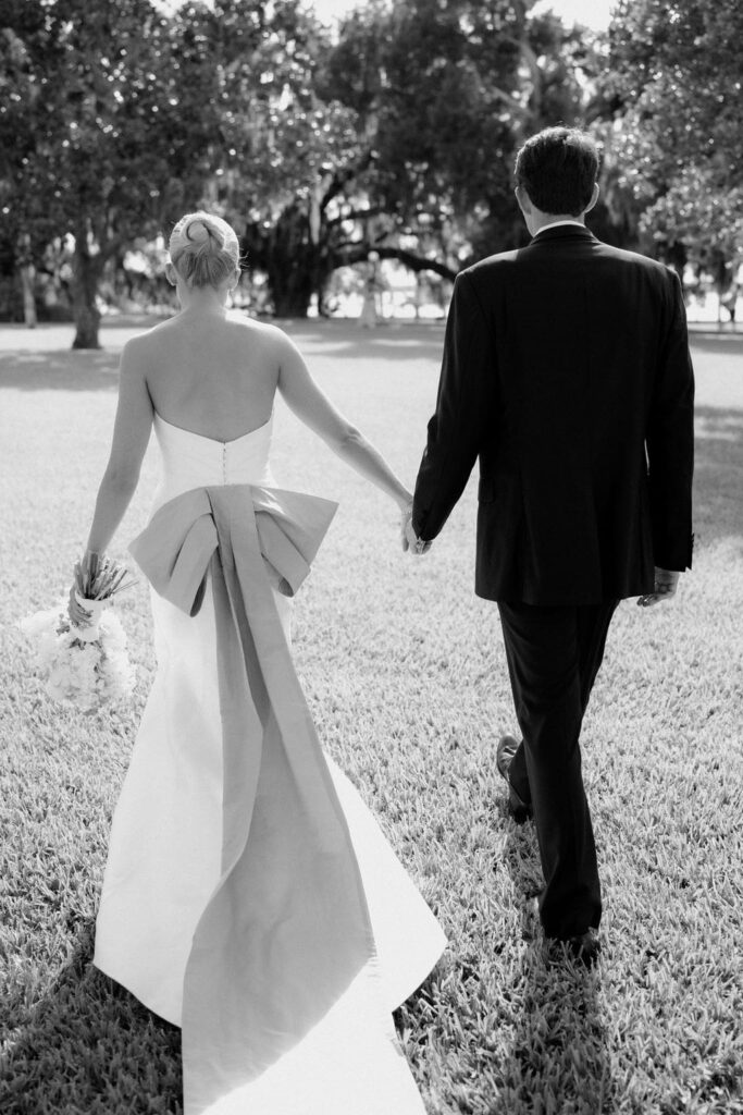 Black and white photo of bride and groom walking