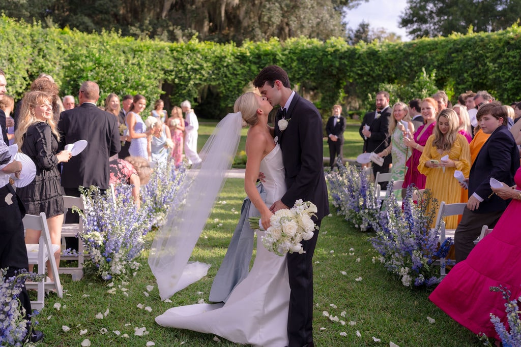 Bride and groom kissing in middle fo wedding aisle