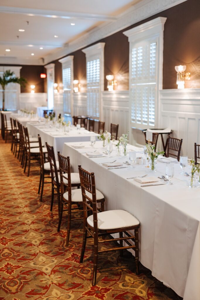 Long tables with brown chairs and white linens