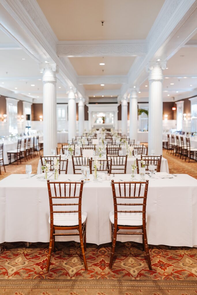 Long tables with brown chairs and white linens