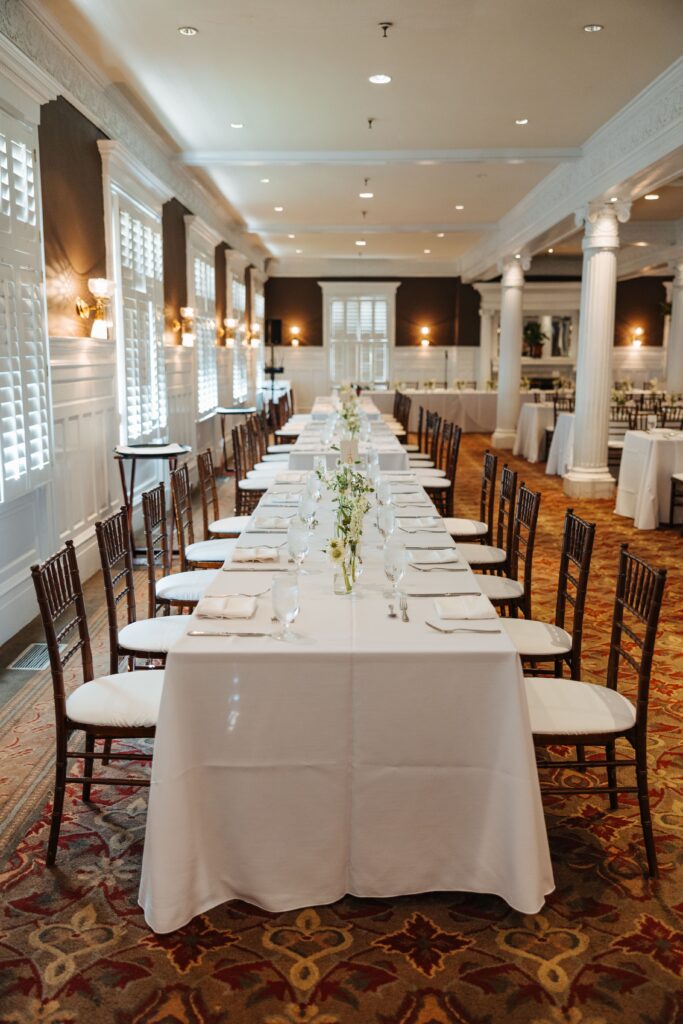Long tables with brown chairs and white linens