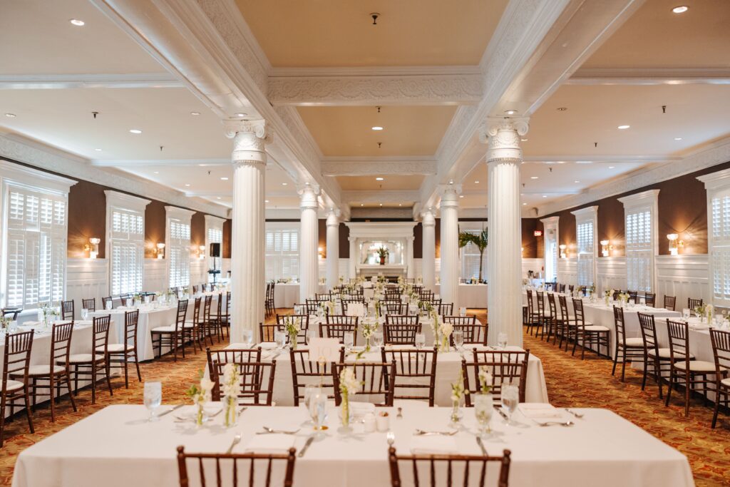 Long tables with brown chairs and white linens at Crane Cottage wedding rehearsal dinner