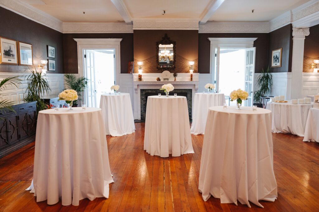 White cocktail tables linens with white flowers on top