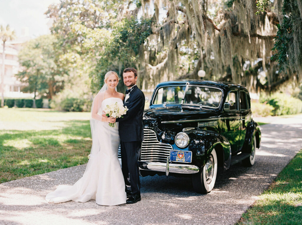 Bride and groom portrait in front of vintage car