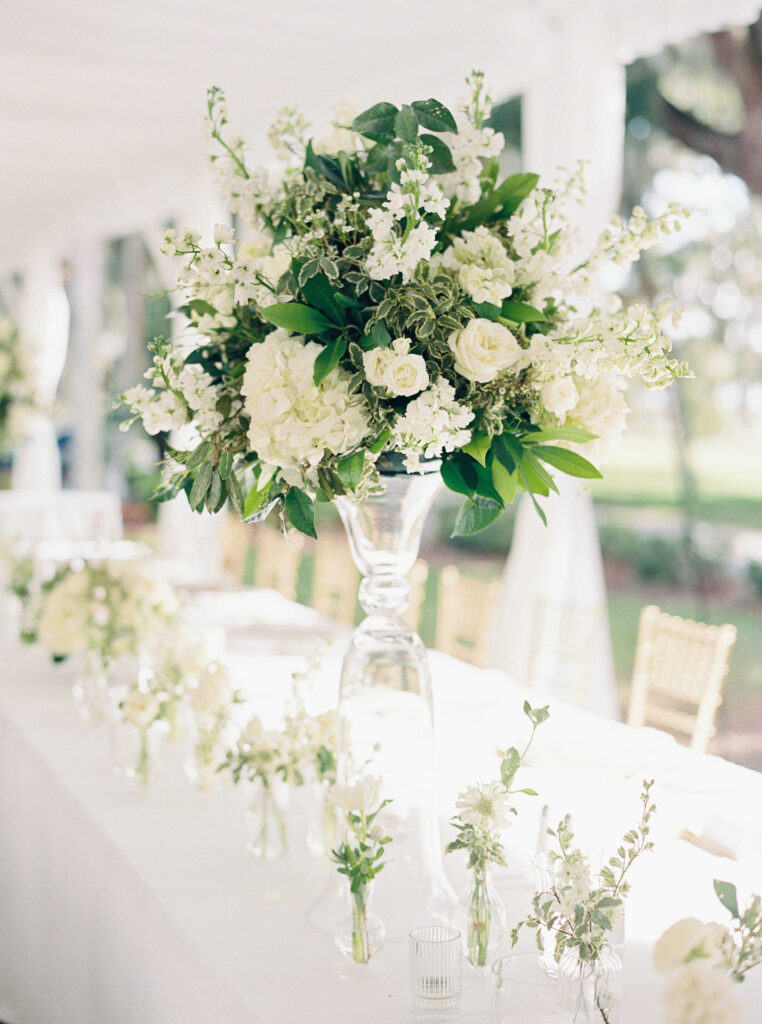 White flowers in tall glass vase at wedding
