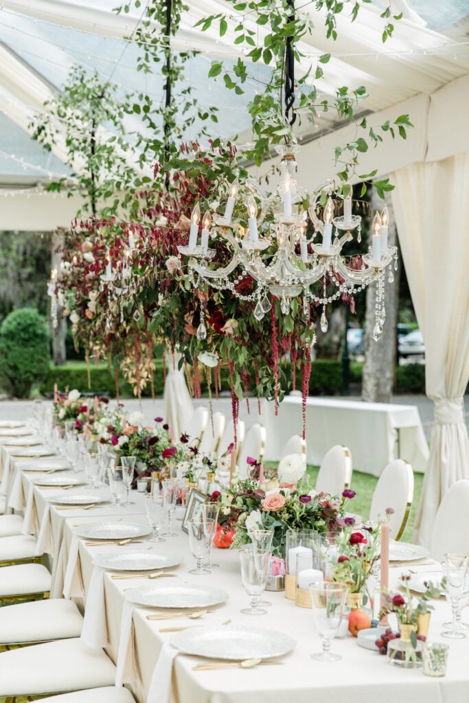 Hanging floral installation with chandeliers above head table