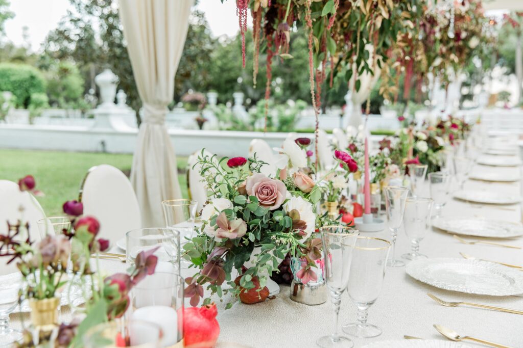 White wedding table with burgundy and mauve flowers 