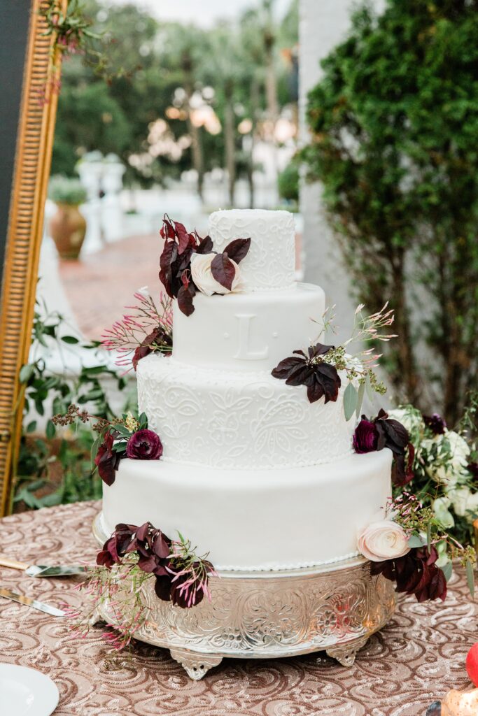 White wedding cake with burgundy flowers