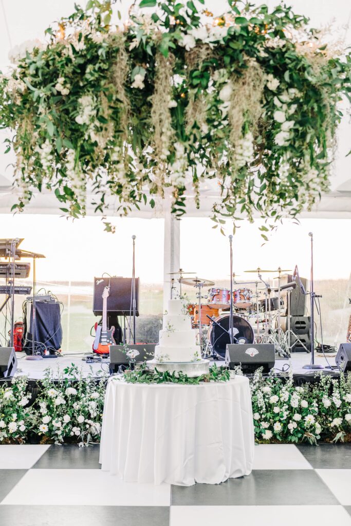 Tented wedding reception with floral chandelier and wedding cake