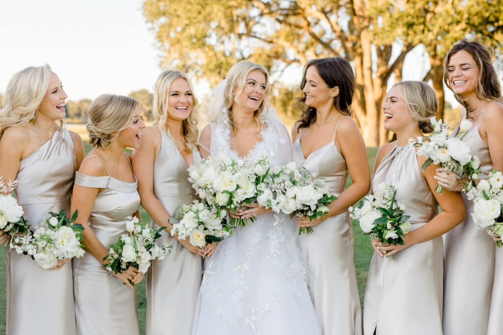 Bridesmaids in champagne silk bridesmaid dresses with white flowers
