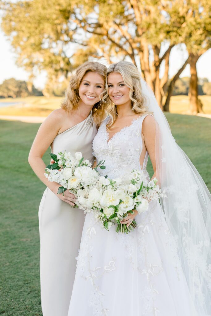 Bridesmaid in champagne silk bridesmaid dress with bride in white wedding dress