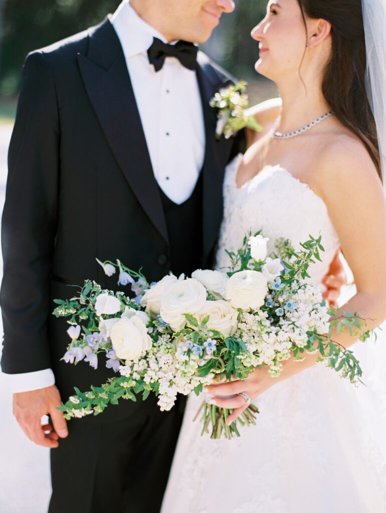 Bride holding white, blue and purple bridal bouquet