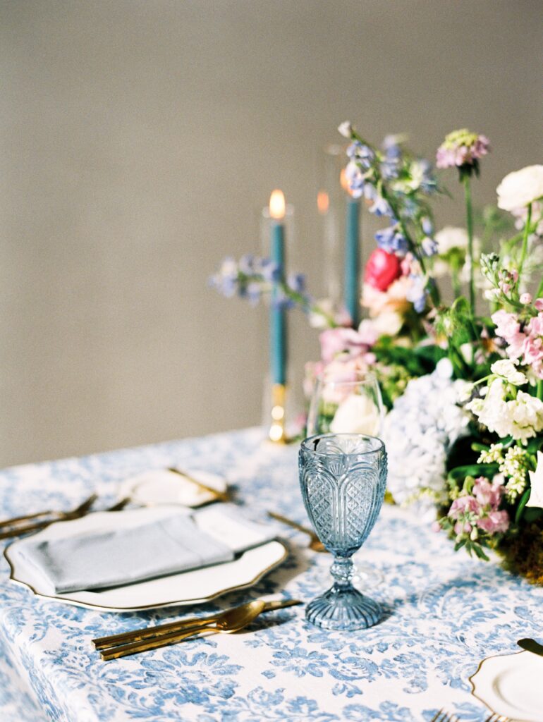 Wedding table with blue and white pattern linen with gold cutlery and blue water goblet